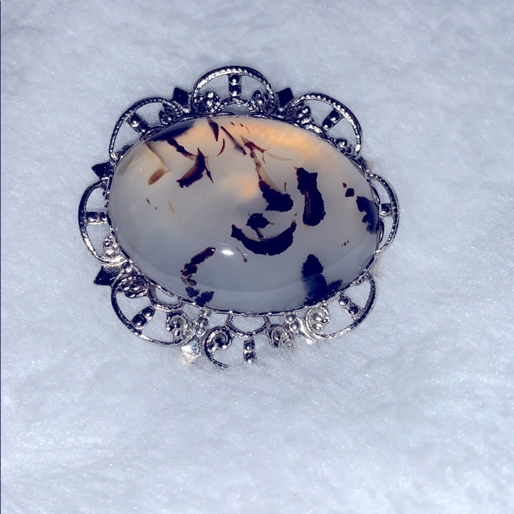 Translucent w/ black accents stone in a silver pin
